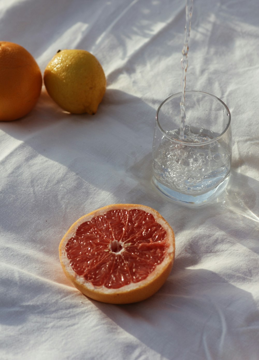 orange fruit beside clear drinking glass