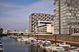 Wide shot of Düsseldorf Medienhafen waterfront with contemporary buildings under a clear sky.