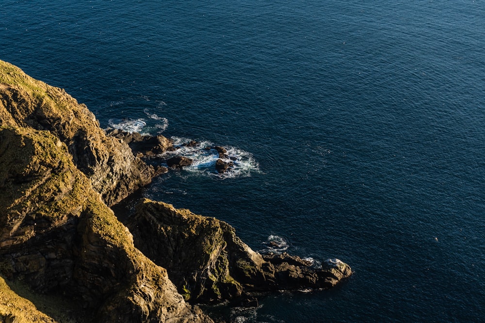 brown rock formation beside blue sea during daytime