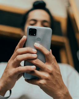 Close-up of hands holding a smartphone showing a detailed product review page.