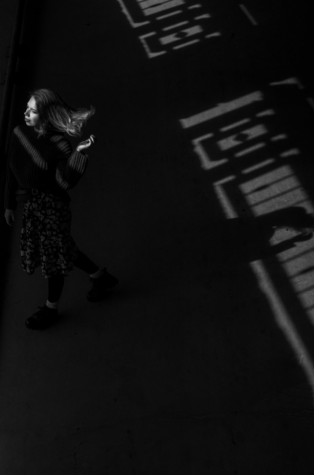 woman in black and white dress walking on pedestrian lane