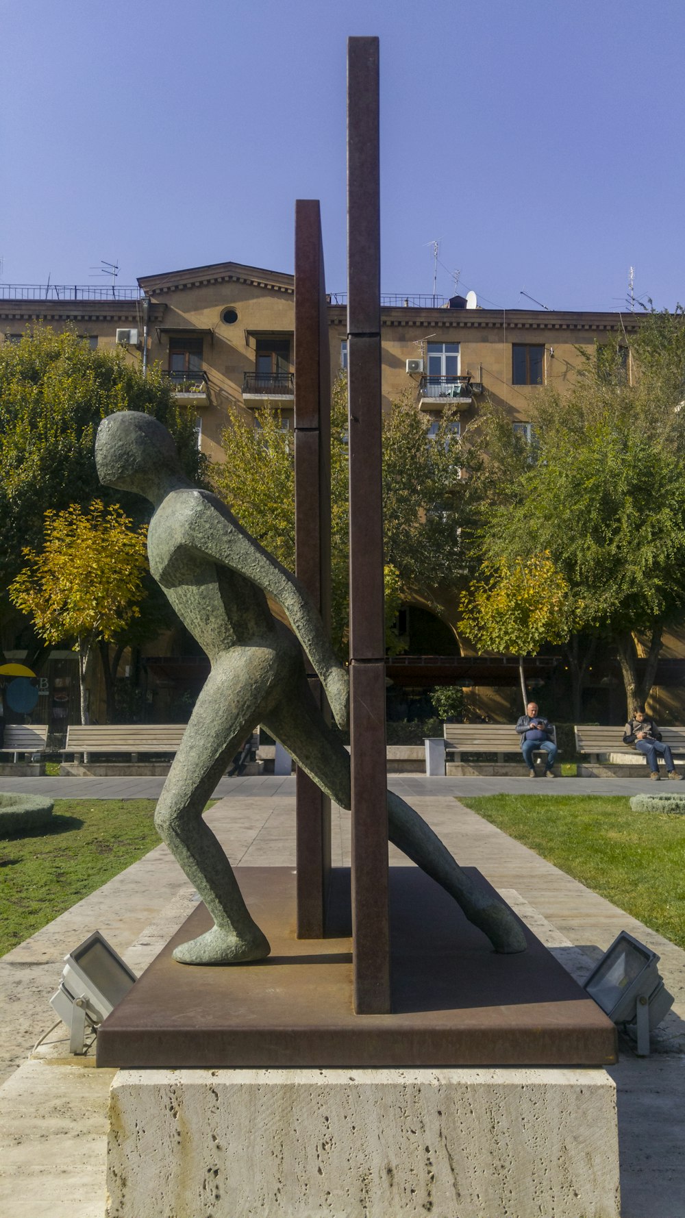 gray concrete statue near brown building during daytime