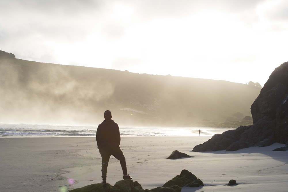 man standing on seashore during daytime