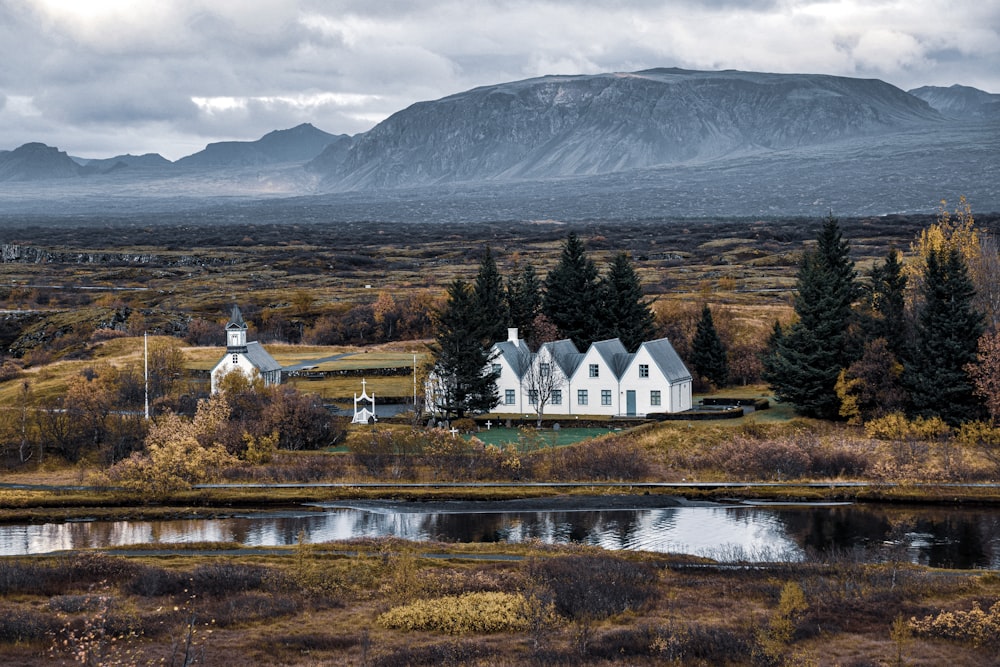 casa branca e marrom perto do lago e da montanha