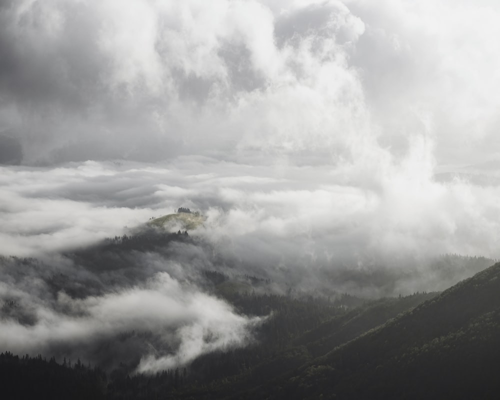 white clouds over green mountains