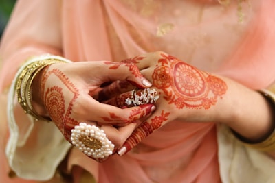 A bride's hands beautifully decorated with bridal chooda and henna designs.