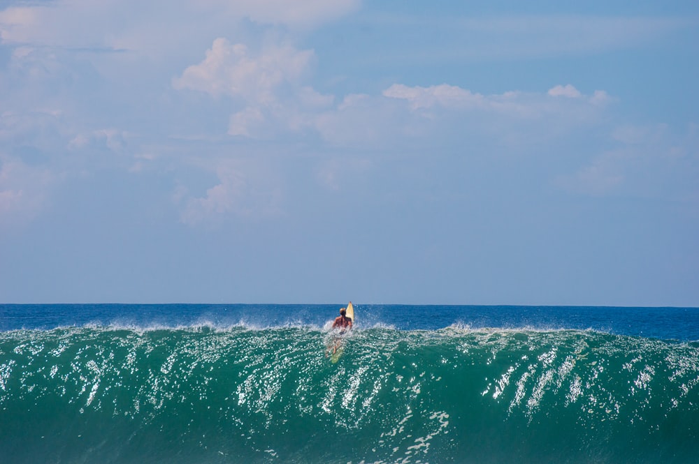 persona che fa surf sulle onde del mare durante il giorno