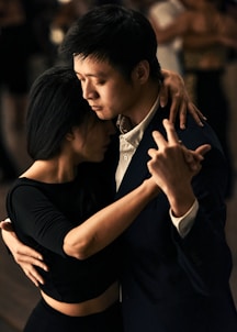 man in black suit kissing woman in black dress