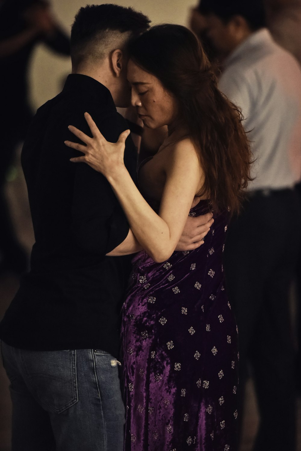 woman in purple and white floral dress kissing man in black shirt