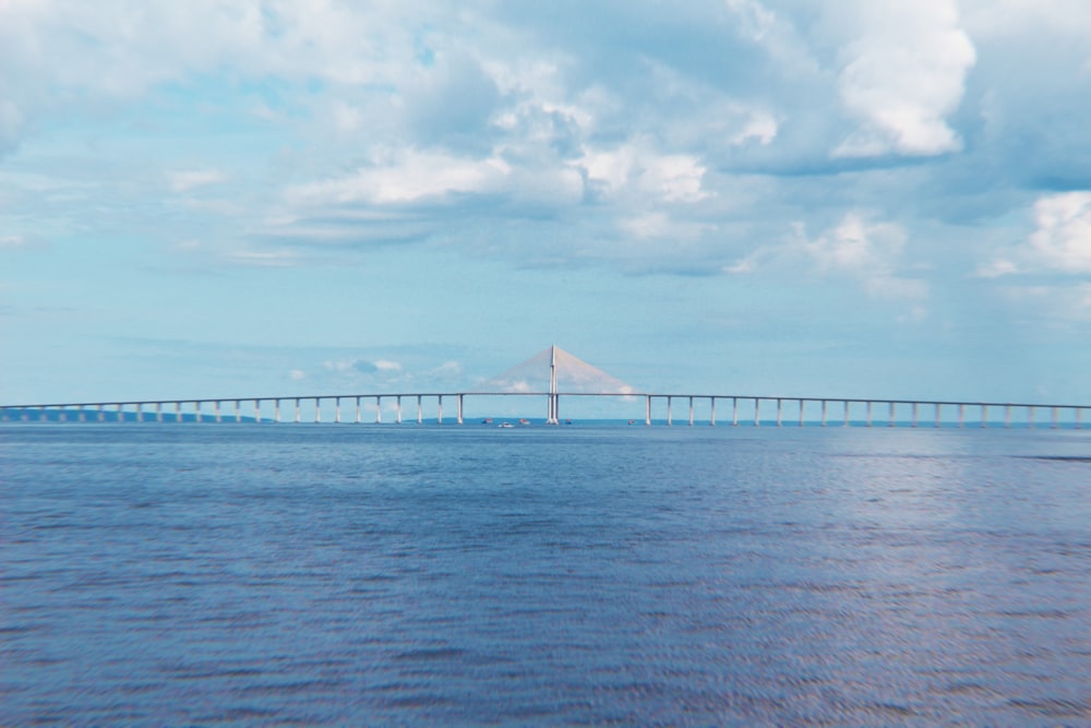 Weiße Brücke über das Meer unter weißen Wolken tagsüber