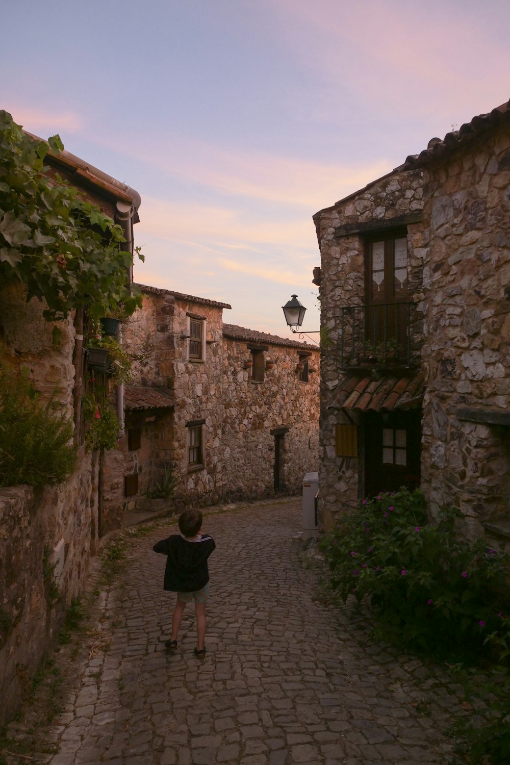 person in black shirt standing near brown concrete building during daytime