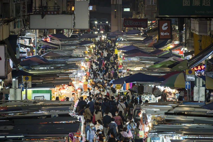 A vibrant photo capturing a lively street market bustling with people and colorful stalls.
