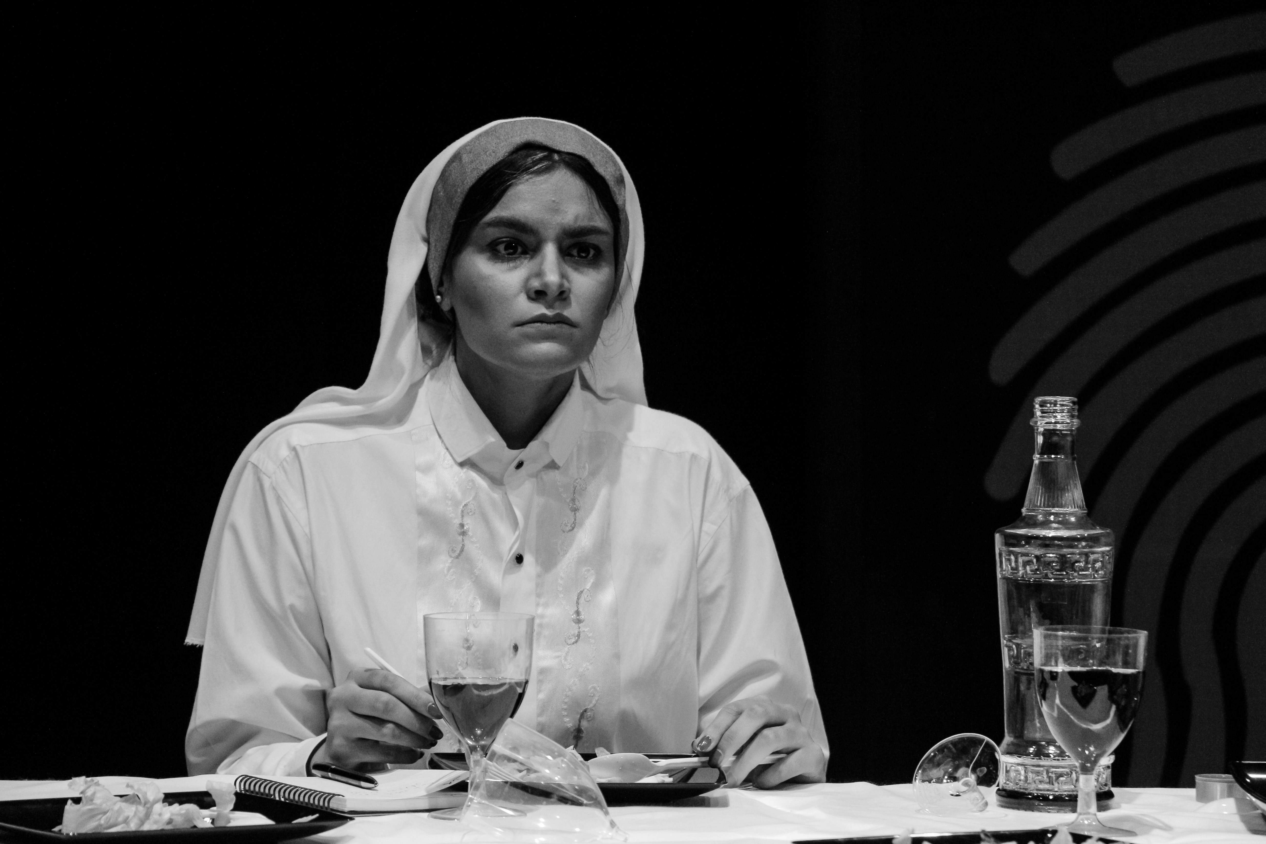 mujer con hiyab sentada a la mesa