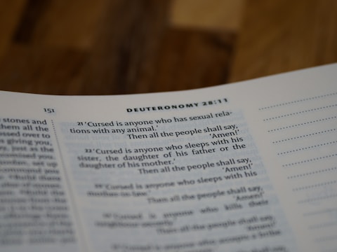 Text on an open page of a religious book, specifically the Book of Deuteronomy, with verses discussing various moral and ethical prohibitions.