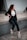 woman in black blazer and black pants sitting on concrete wall during daytime