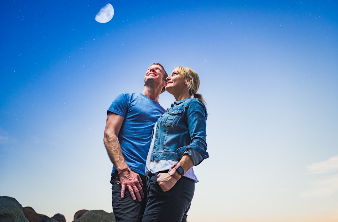 man in blue denim button up shirt kissing woman in blue denim jacket during daytime