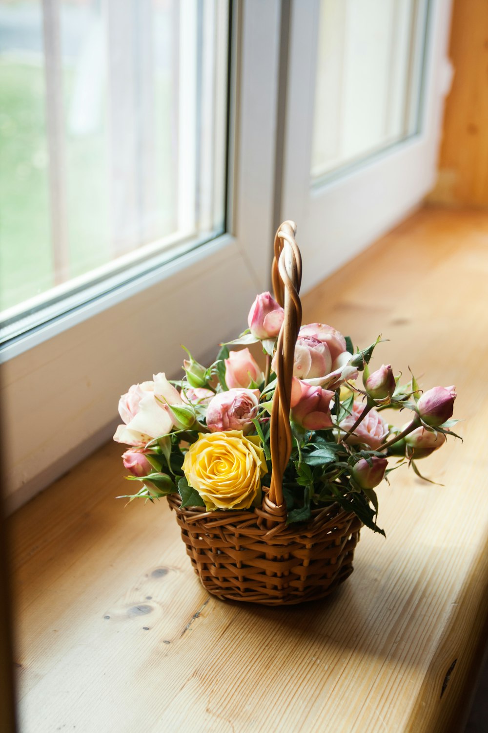 pink and white roses in brown woven basket