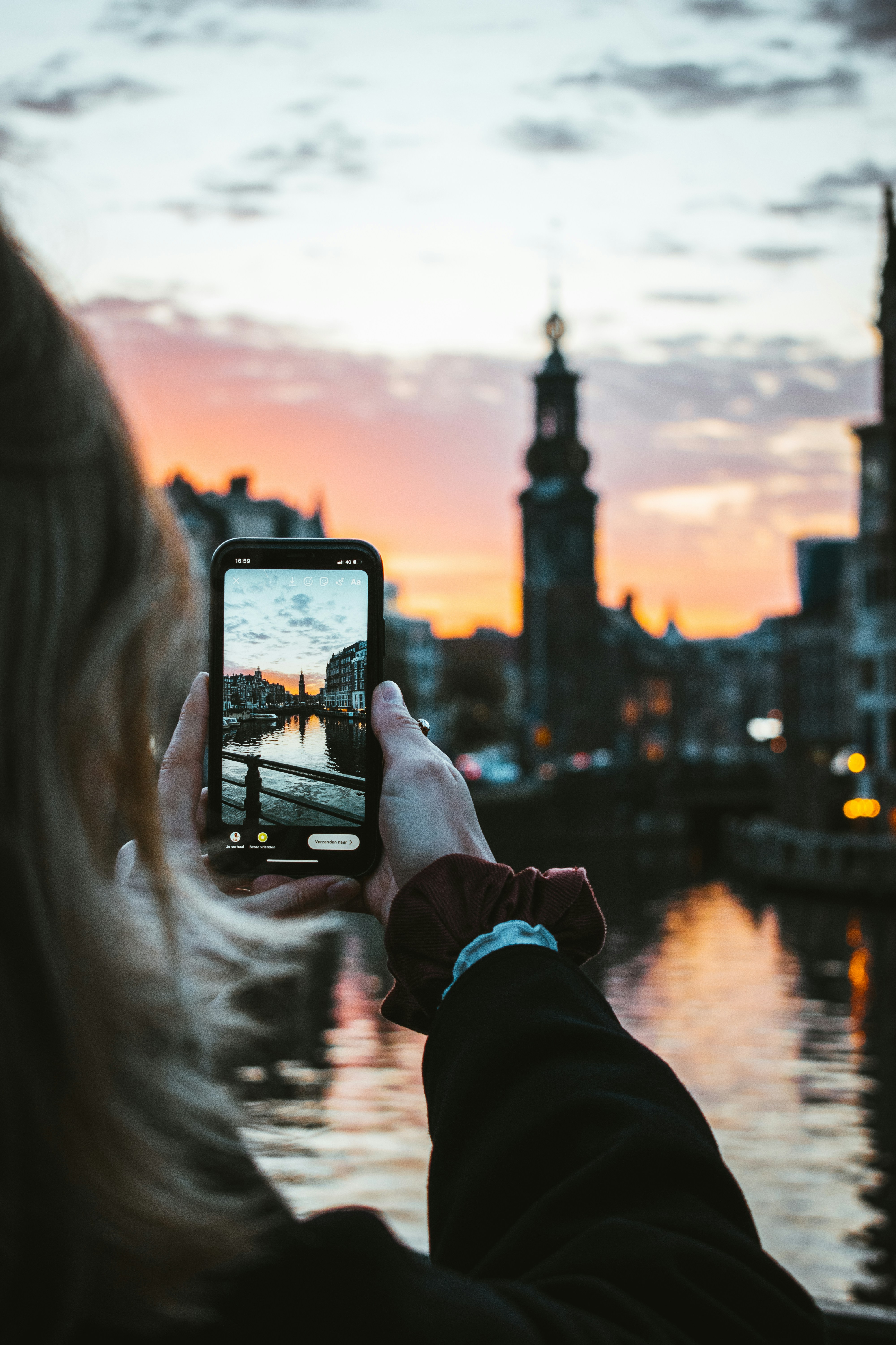person-holding-black-smartphone-taking-photo-of-city-buildings-during-sunset