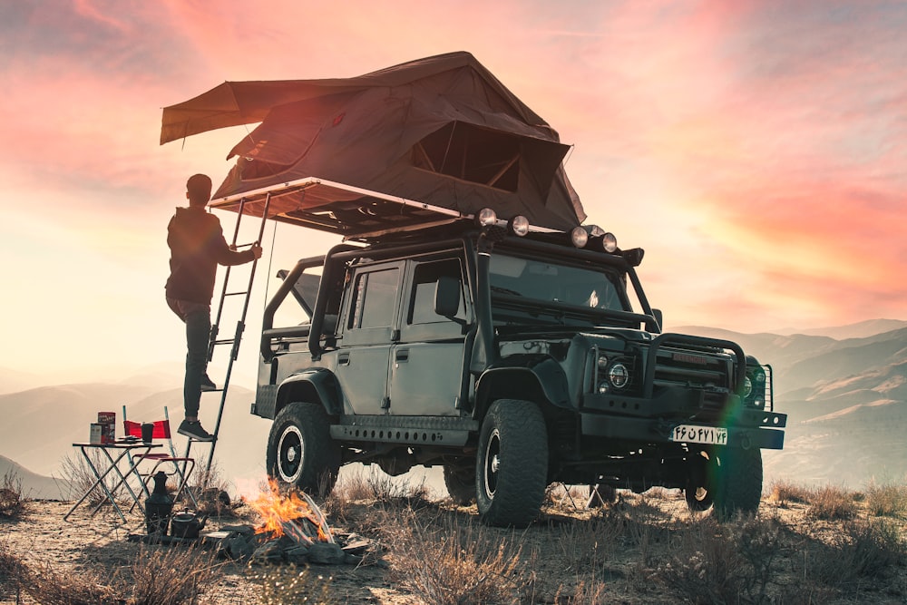 man and woman standing beside black jeep wrangler