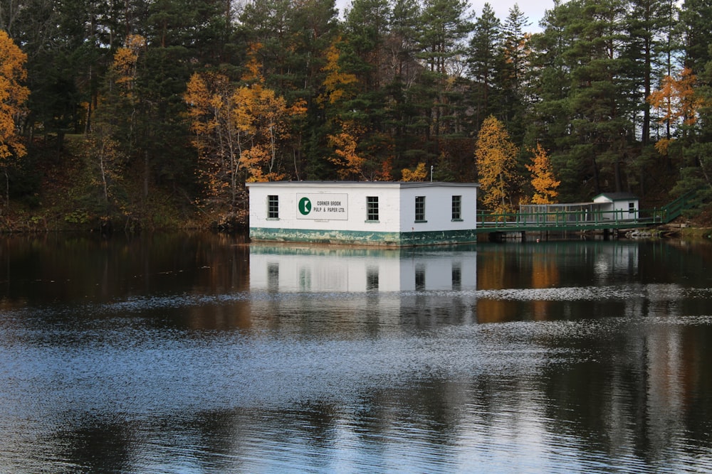 昼間は木々に囲まれた湖のほとりにある白と青の家の写真 Unsplashで見つけるグレーの無料写真