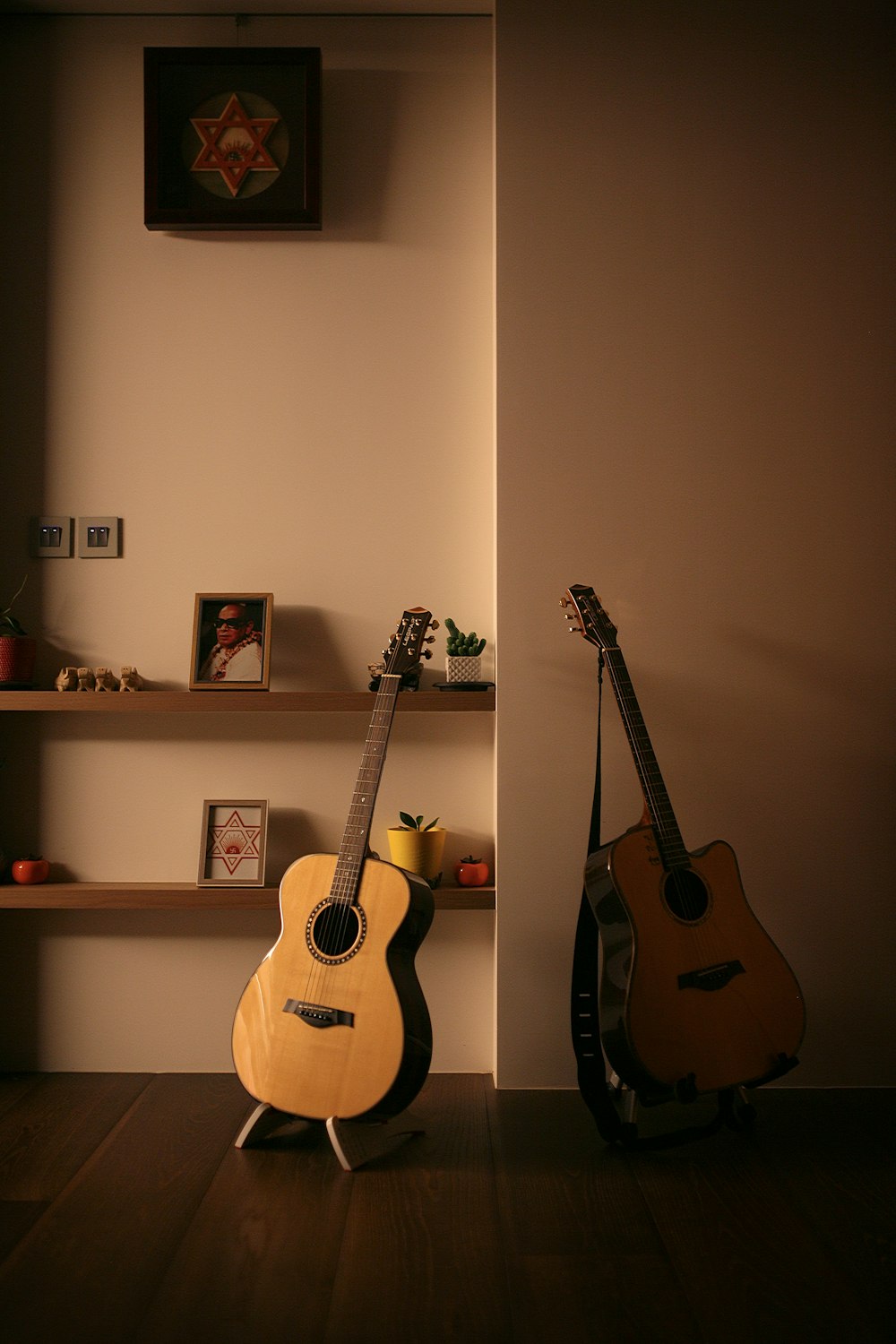 brown acoustic guitar on white wall