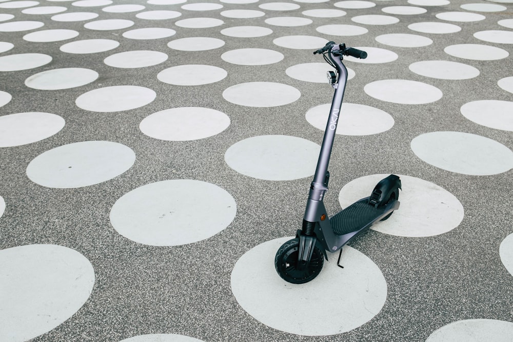 black and gray kick scooter on gray concrete floor