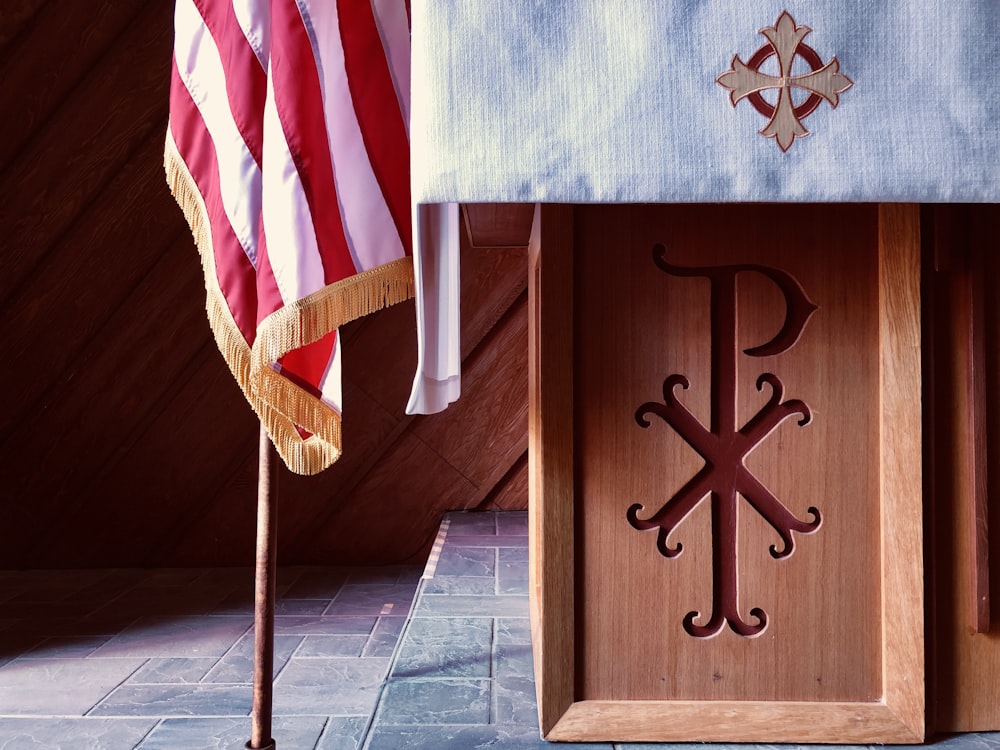 茶色の木製の十字架、上部に米国の国旗