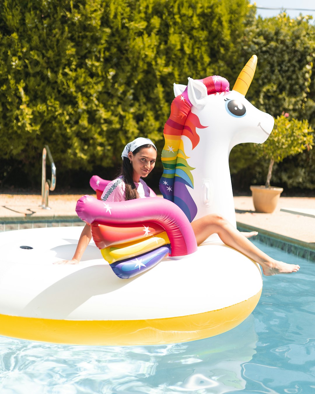 girl in pink and white polka dot dress riding white and pink inflatable duck