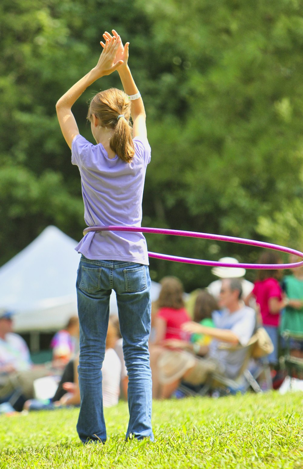 woman in white t-shirt and blue denim jeans holding red and white rope during daytime