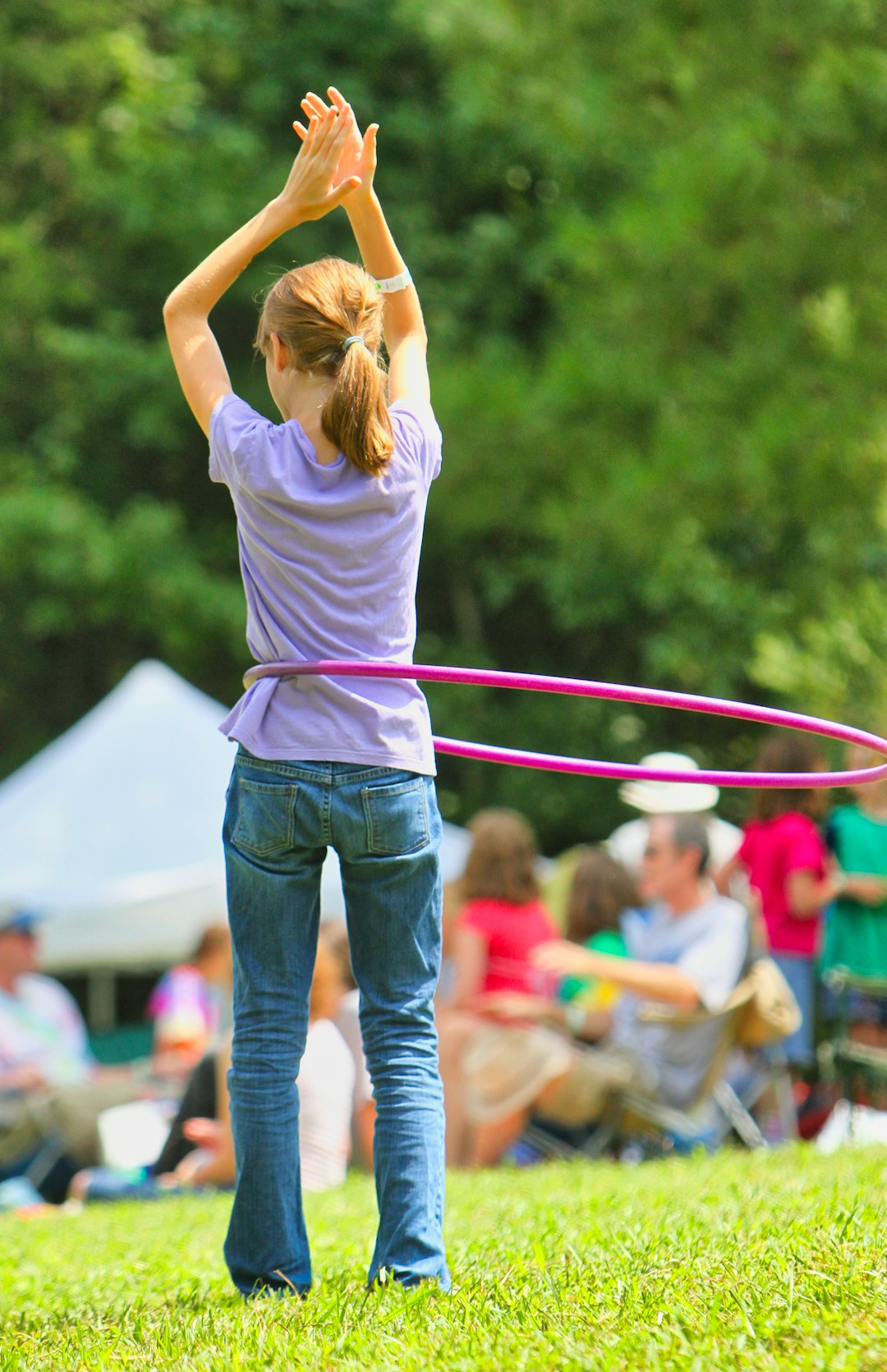 woman in white t-shirt and blue denim jeans holding red and white rope during daytime