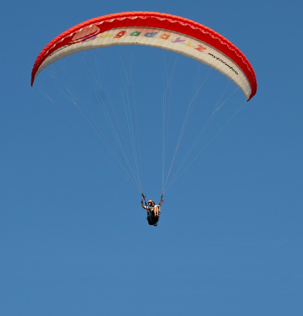 person in yellow parachute in mid air during daytime
