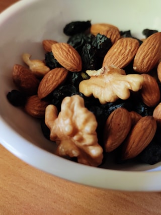 brown and black nuts on white ceramic bowl