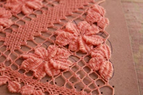 Close-up of delicate crochet work in progress with soft forest-themed background.
