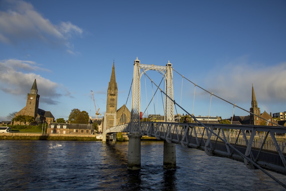 a bridge over a body of water with buildings in the background