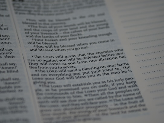 Text from a religious or spiritual book is visible on an open page. The words are printed in a formal font, and the page is filled with neatly organized columns of text. The focus is on a specific passage that appears to be discussing blessings and protection.