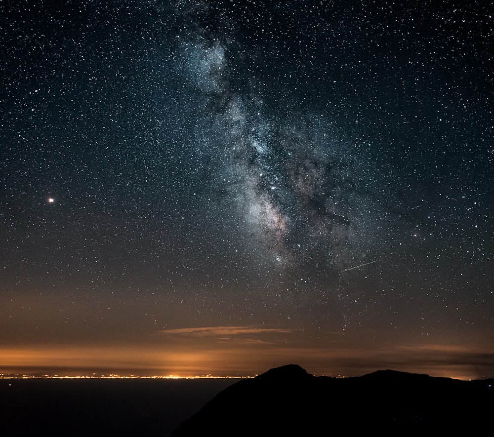 Silueta de montaña bajo la noche estrellada