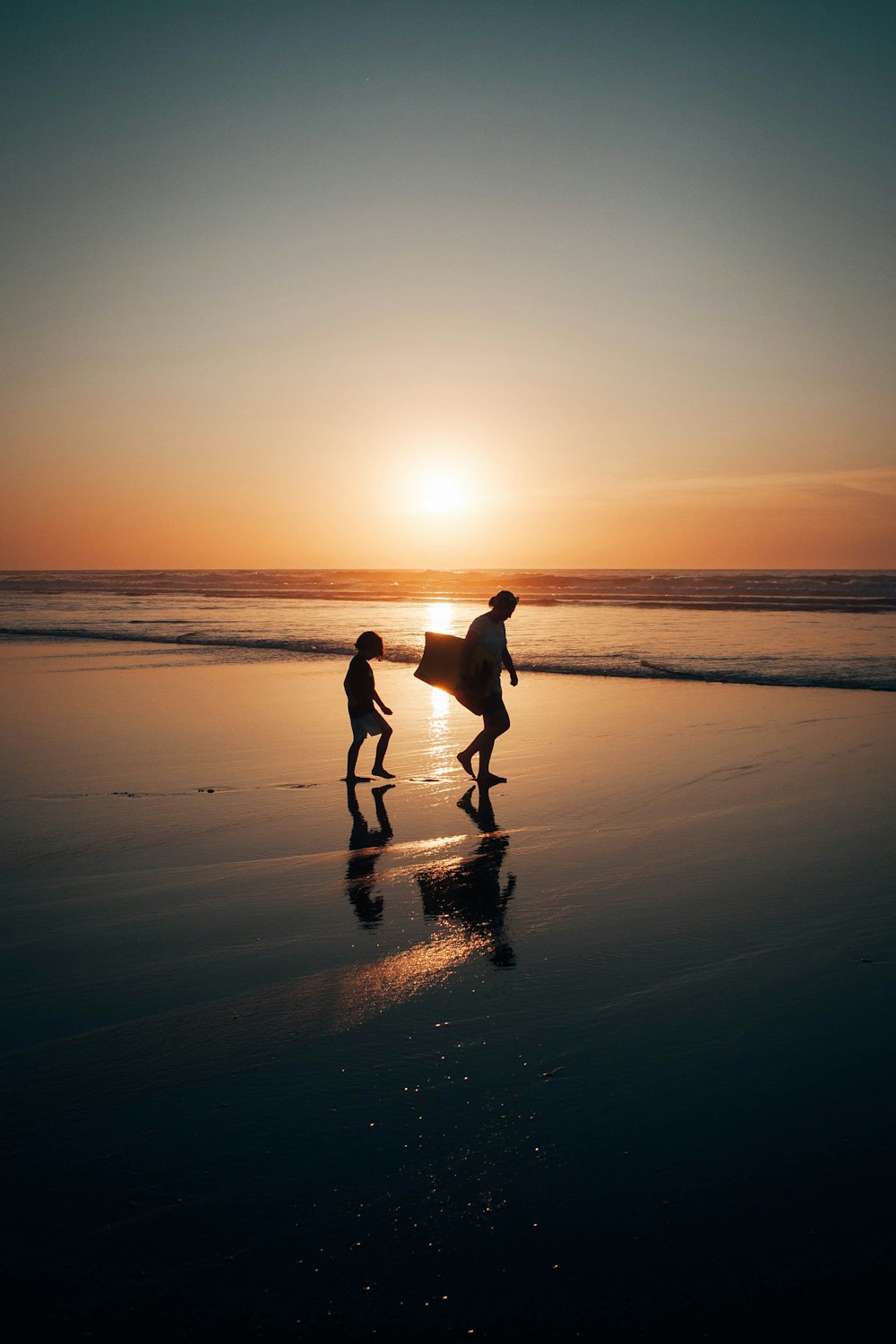 夕暮れ時にビーチを歩く2人の男性