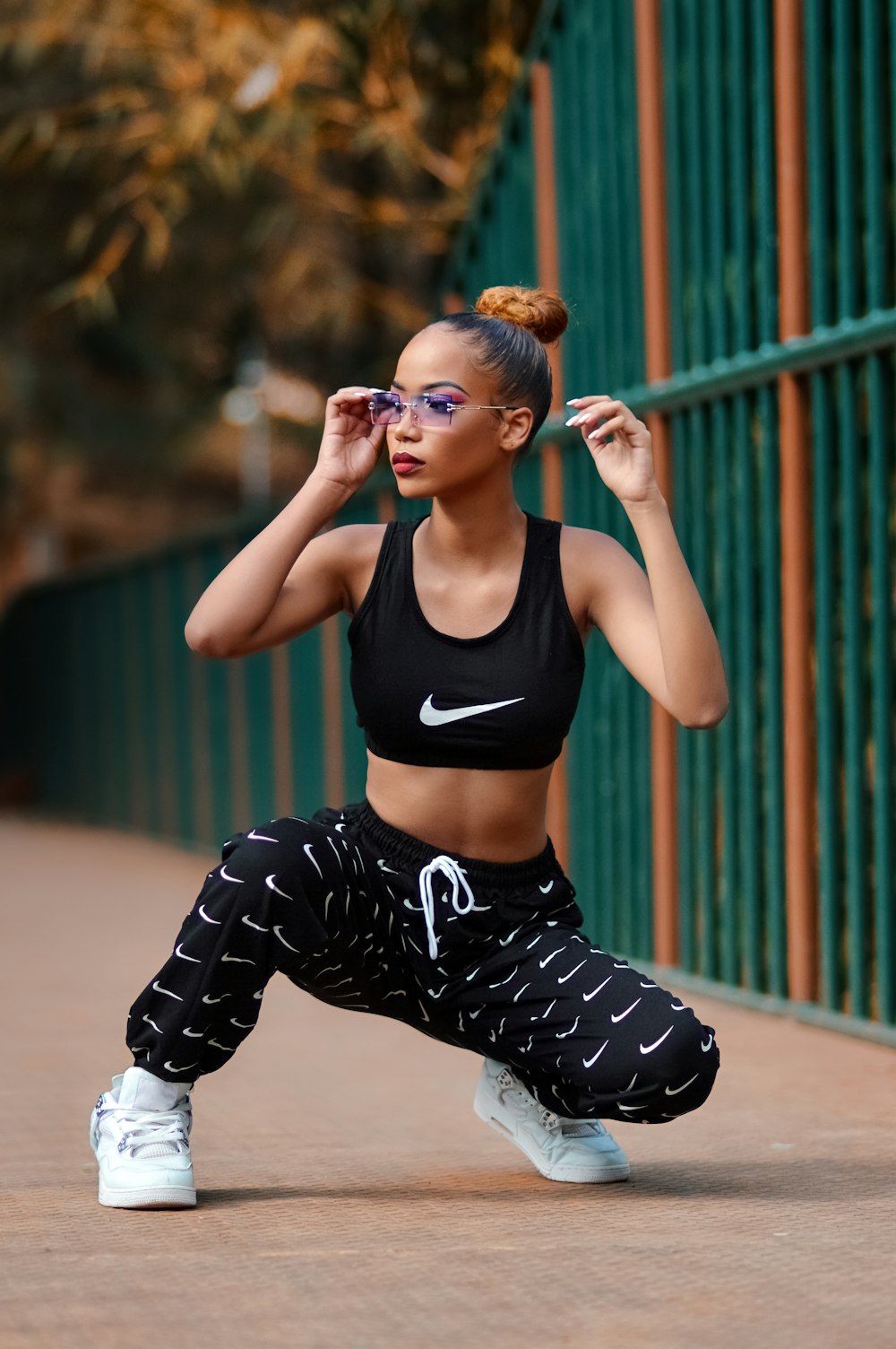 woman in black sports bra and black and white pants sitting on floor