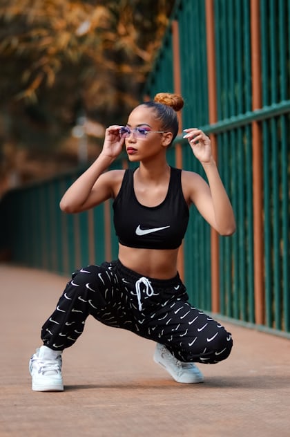 Woman in black sports bra and black and white pants sitting on