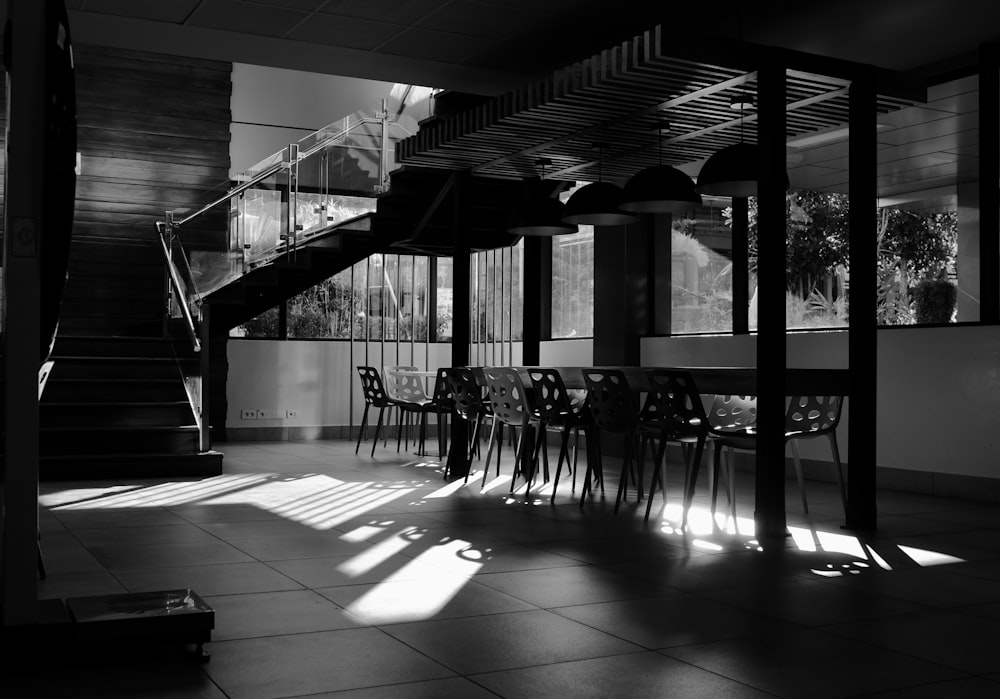 grayscale photo of empty chairs and tables