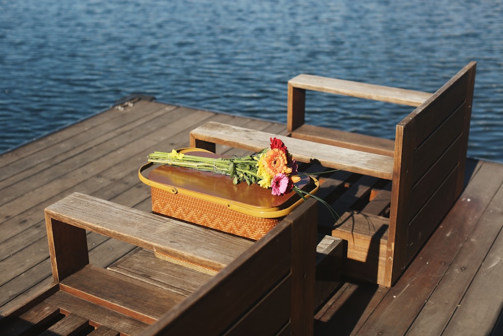 a suitcase with flowers on a wooden dock