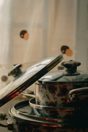 An overhead shot of a five-piece purple pot set neatly displayed on a marble kitchen island.