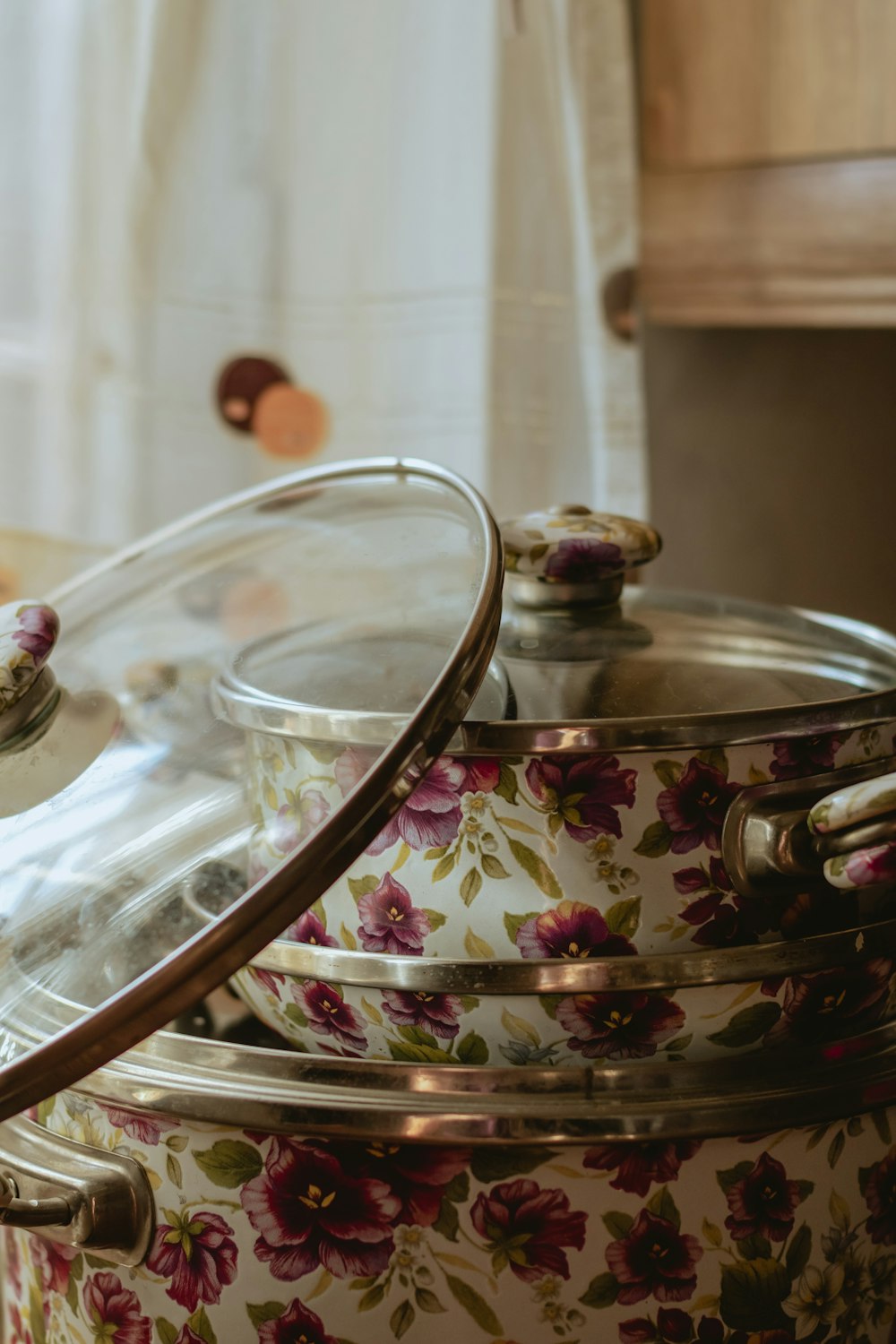 a glass lid on a pot with flowers on it