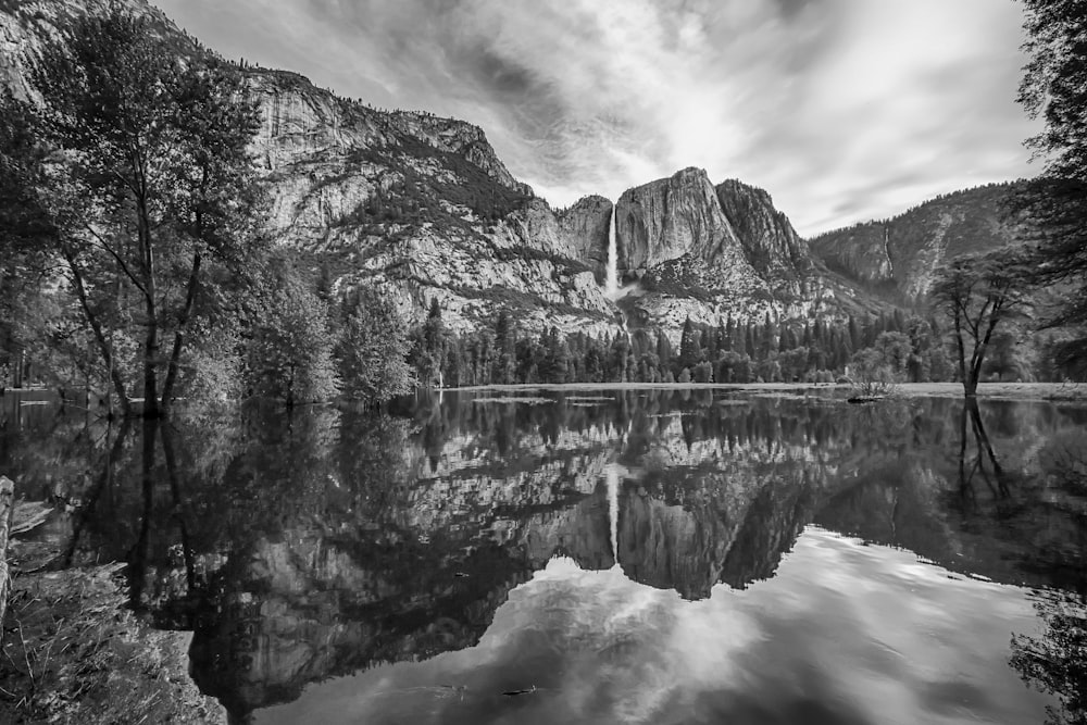 grayscale photo of lake near mountain