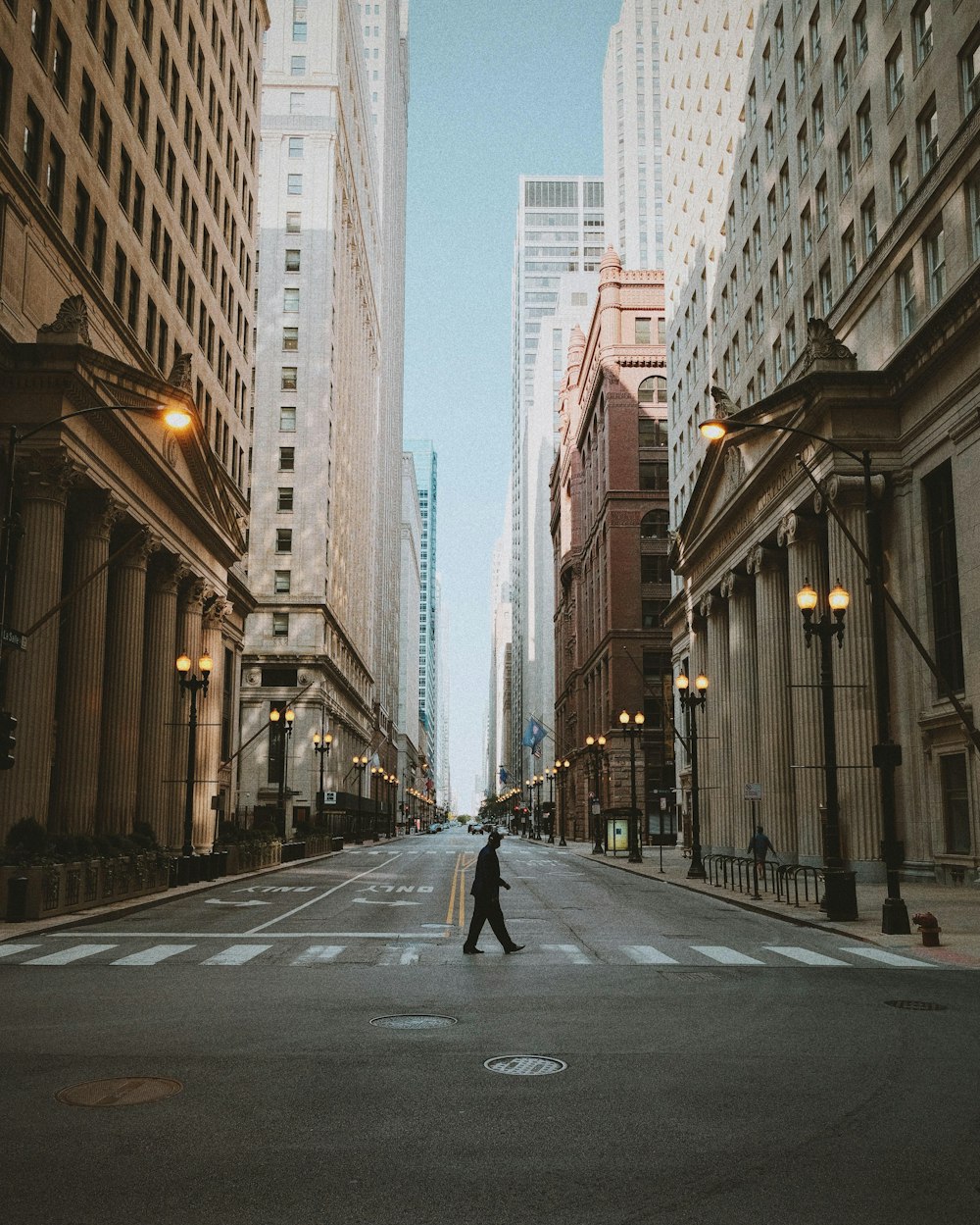 man in black jacket and black pants walking on sidewalk during daytime