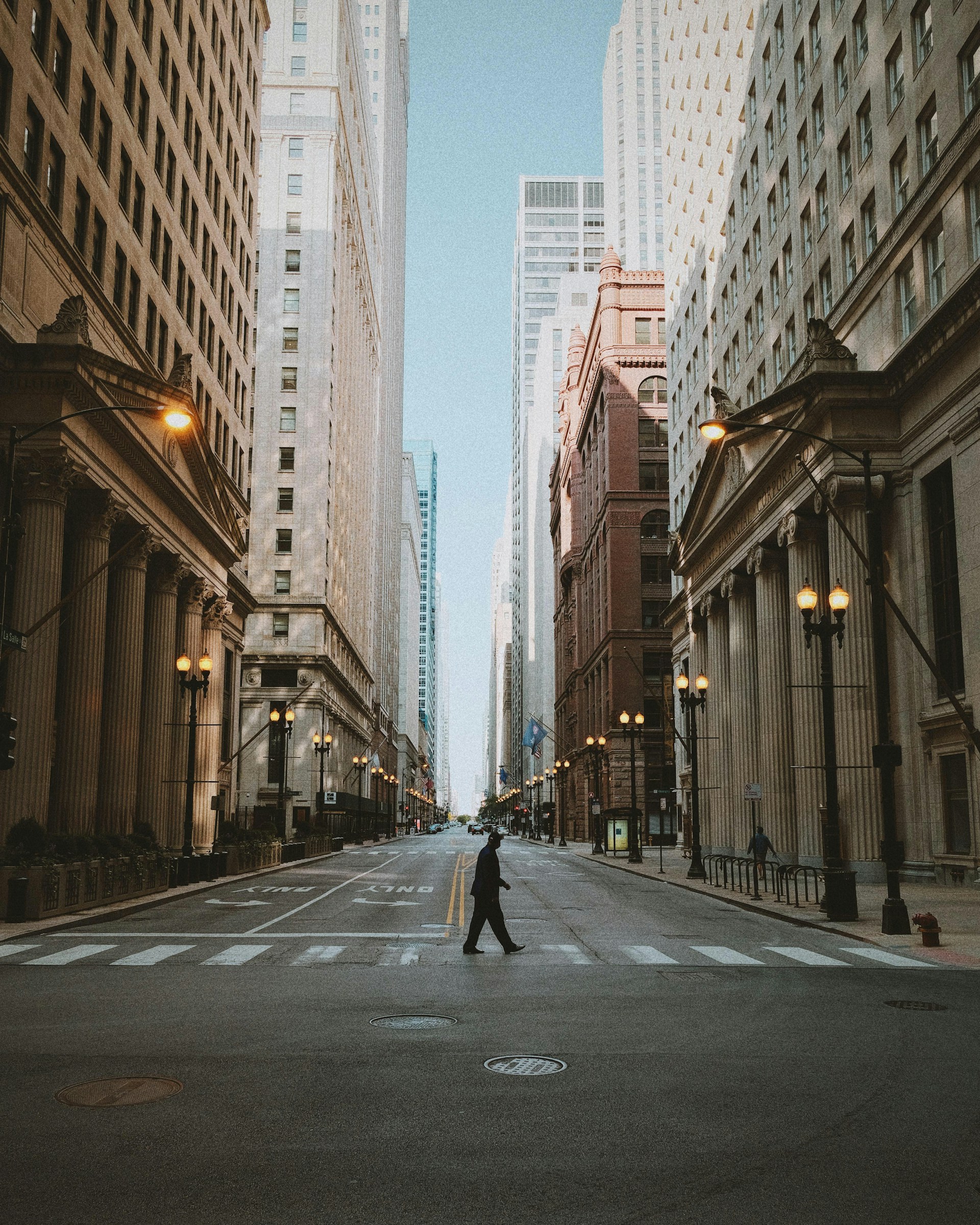 man in black jacket and black pants walking on sidewalk during daytime