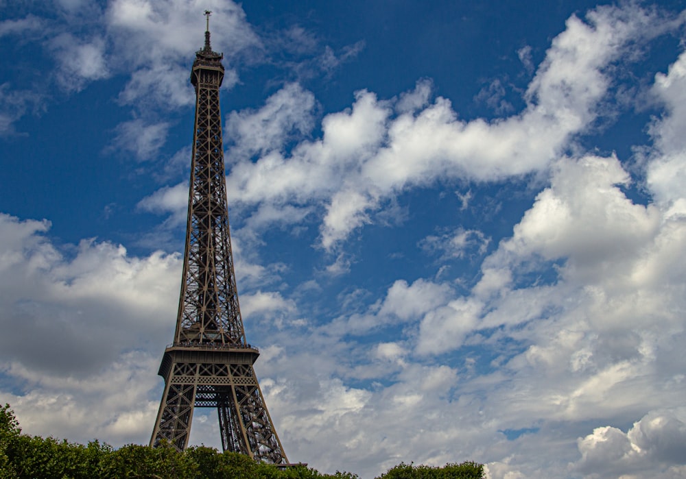 Tour Eiffel sous ciel bleu et nuages blancs pendant la journée