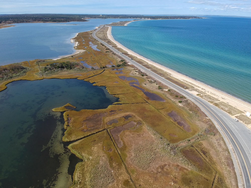 aerial view of green and brown land near body of water during daytime