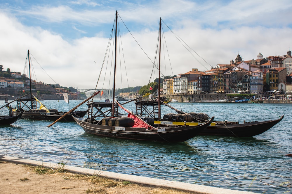 black boat on sea shore during daytime