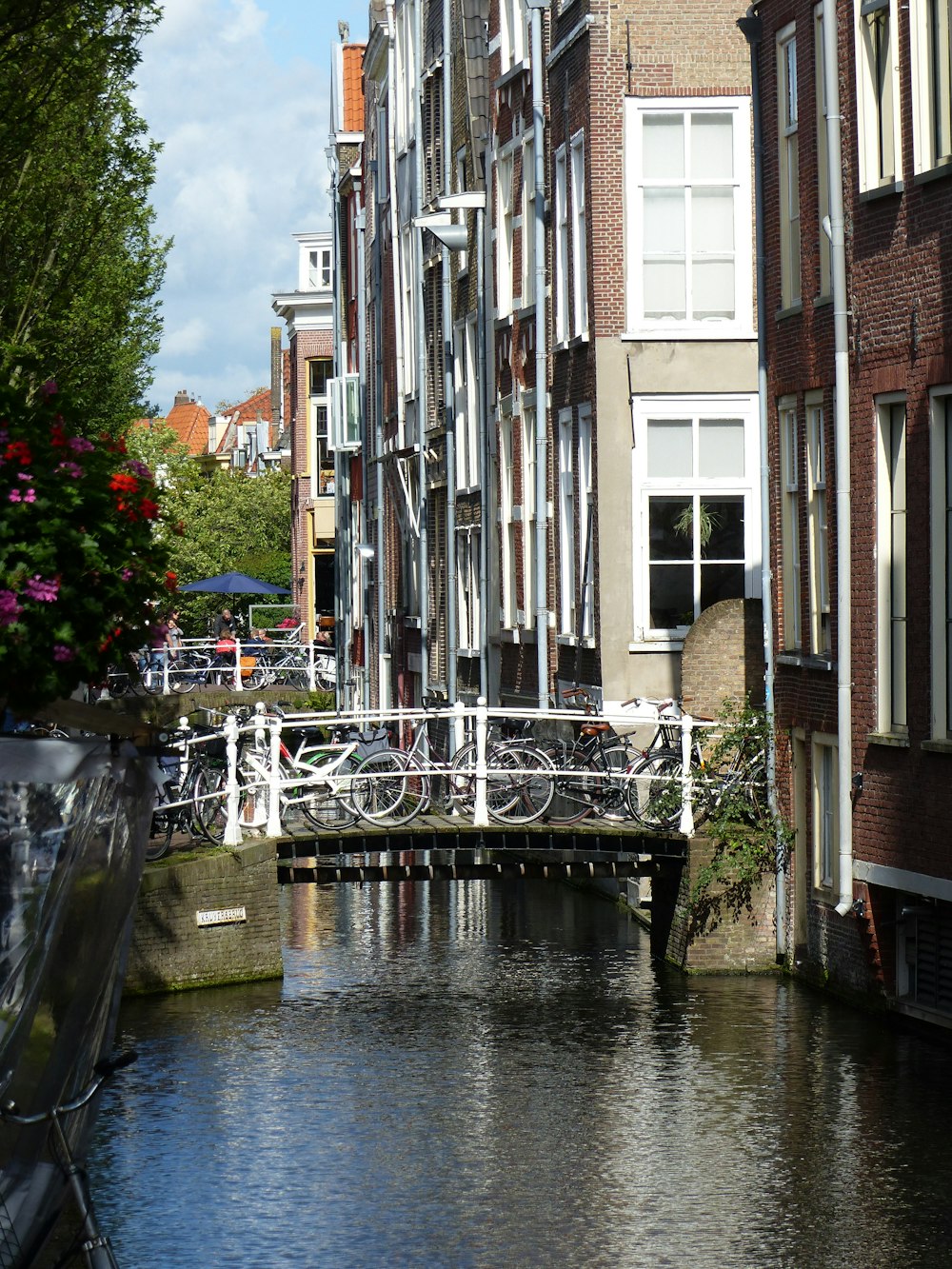 white metal bridge over river between buildings during daytime